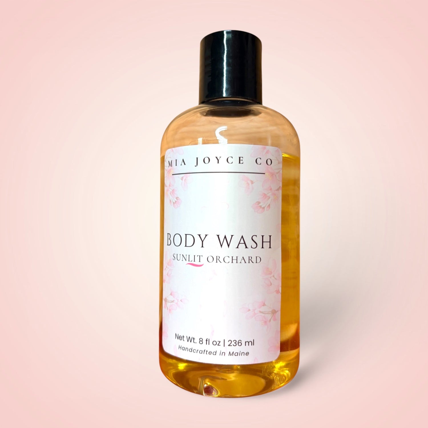 Bottle of Mia Joyce Co. body wash on a pink background
